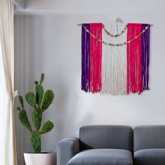 Large boho macramé wall hanging in purple, pink, and white yarn with draped wooden beads on a dowel, 4ft x 4ft.