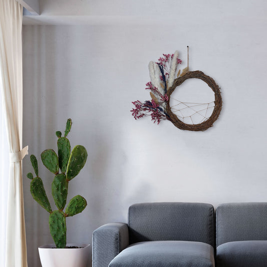 Handmade dreamcatcher wall hanging with crescent-shaped grapevine wreath, dried white pampas grass, and purple-pink preserved flowers.